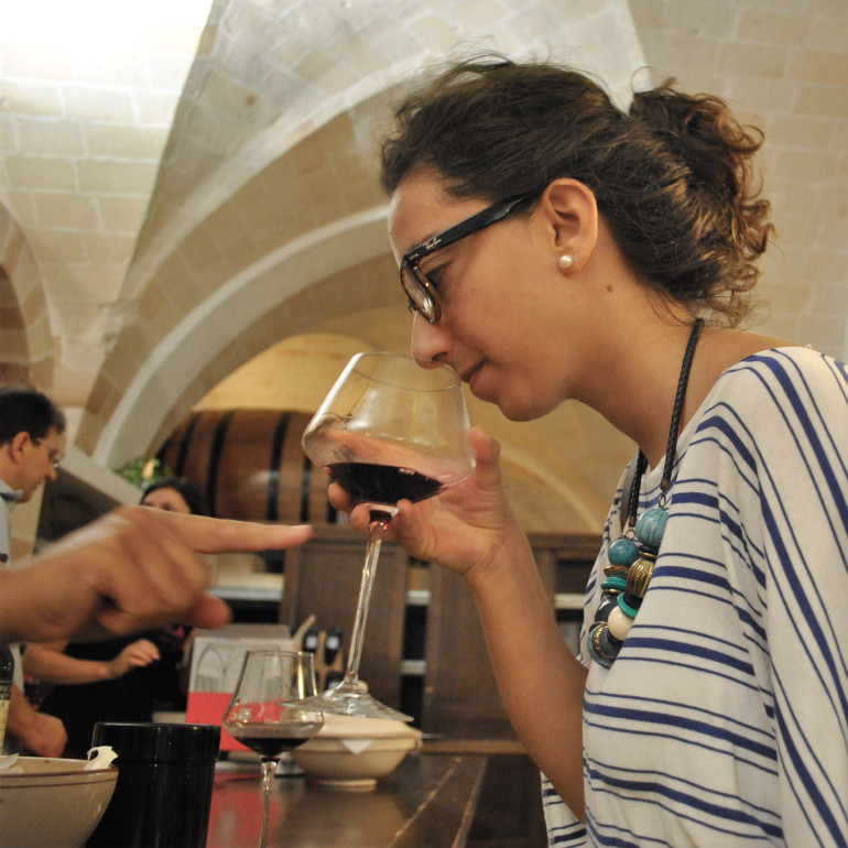 Lucia sniffs Primitivo di Manduria in Manduria. by Dauno Settantatre