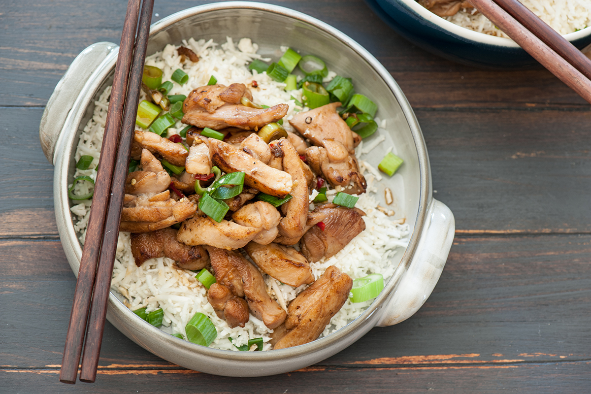 Kung Pao chicken and rice with chopsticks.