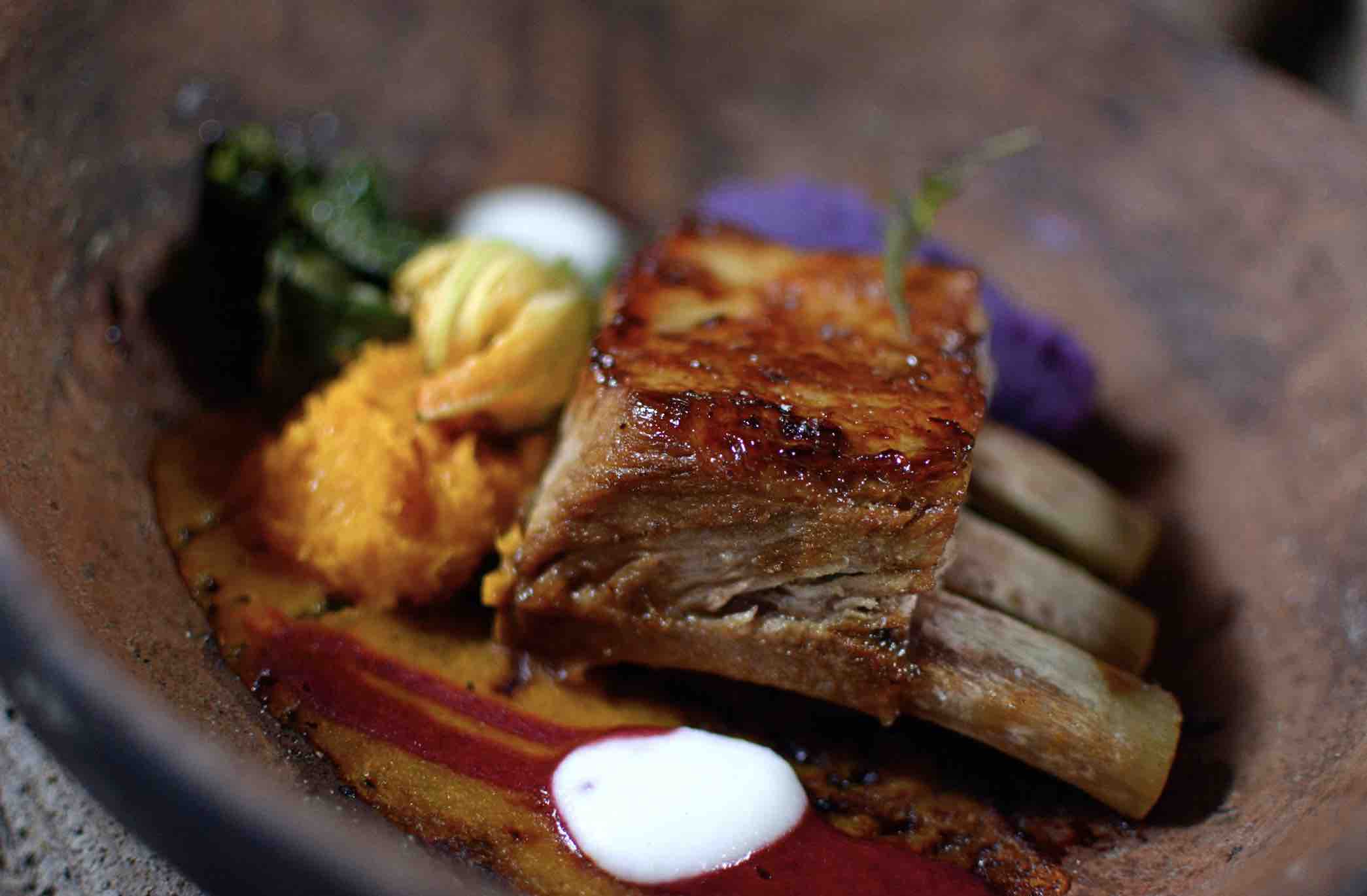 Picture of Roasted belly on the bone presented nicely on a dark plate