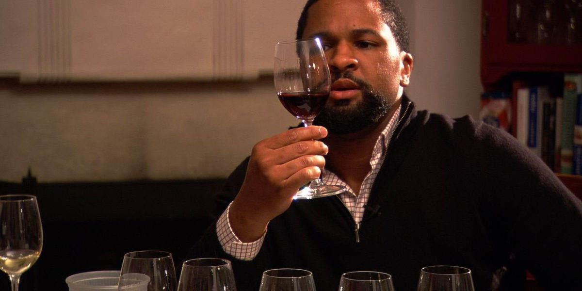 Dlynn studying a glass of wine in Somm movie